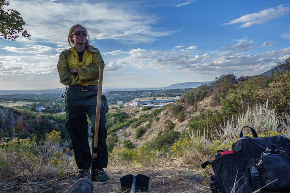 photo of a female firefighter on a hilltop overlooking Salt Lake City